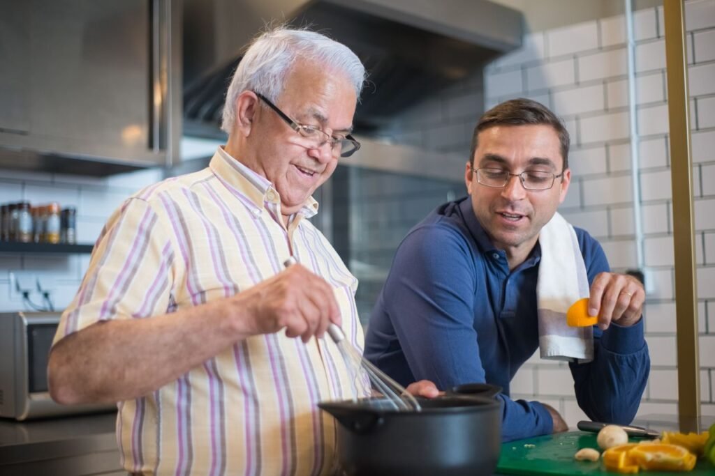 Person-Centred Care in Plain English An older man preparing a meal independently while a care worker supports nearby